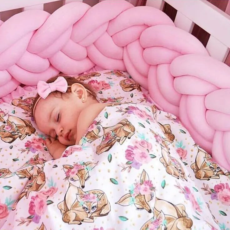 baby girl sleeping in white crib with solid light pink double braided bumper, deer print bedding, safe for newborns