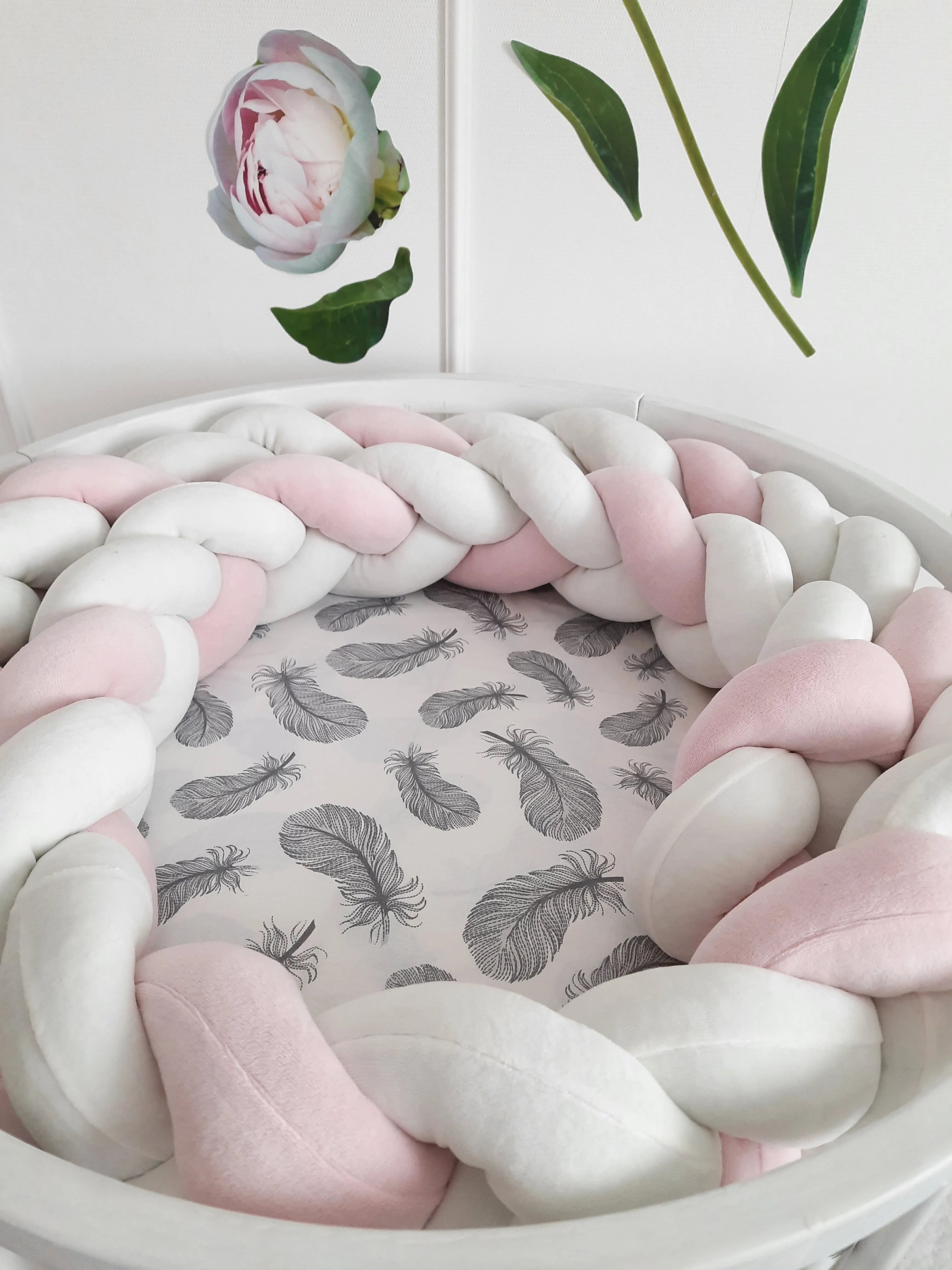 White pink 3-strand braided crib bumper in round white crib with feather print sheet, handmade cotton nursery decor