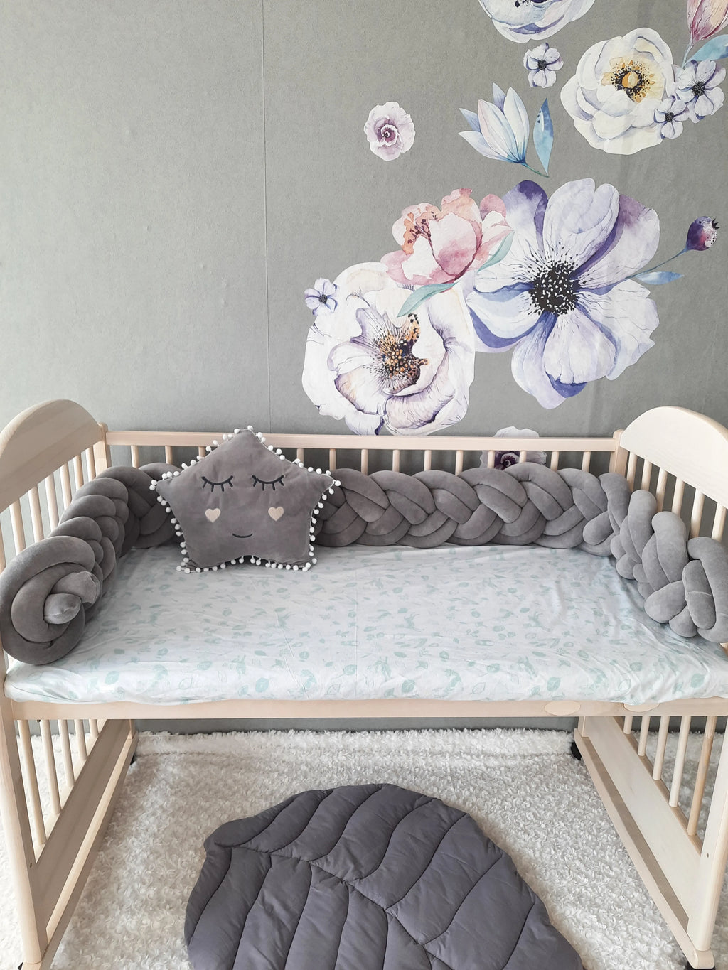 solid gray double braided crib bumper in natural wood standard crib, star pillow, floral wall nursery