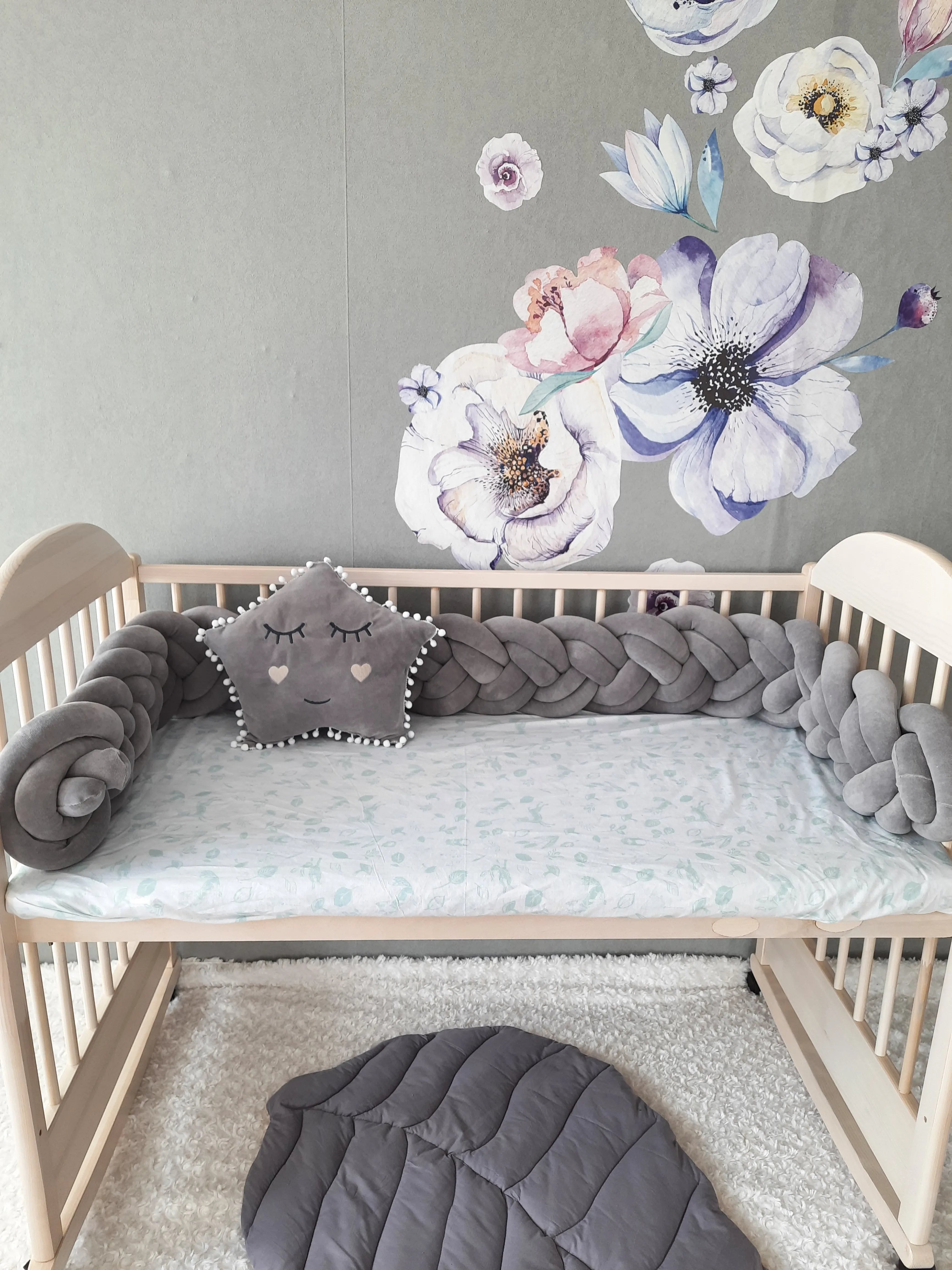solid gray double braided crib bumper in natural wood standard crib, star pillow, floral wall nursery