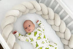 Baby lying in crib with milk 3-strand braided bumper, safe soft crib rail protection, CottonNest