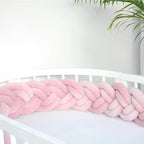 pink braided crib bumper on white round crib close-up soft cotton velour