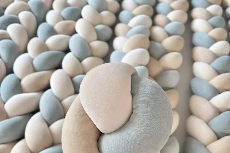 Close-up of white gray blue 3-strand braided crib bumper texture, soft OEKO-TEX cotton velour, hypoallergenic fill