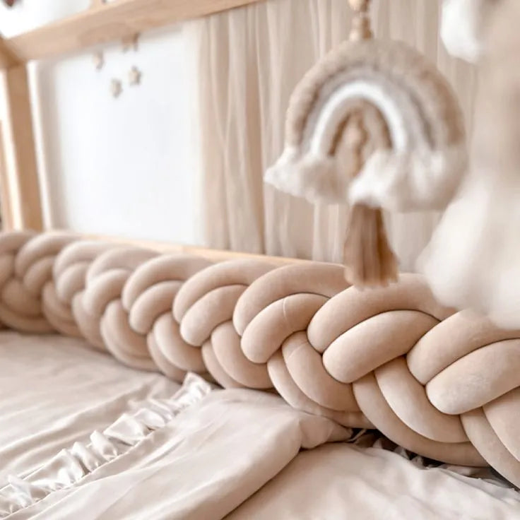 solid cream double braided crib bumper on house bed frame with macrame rainbow decor, boho nursery