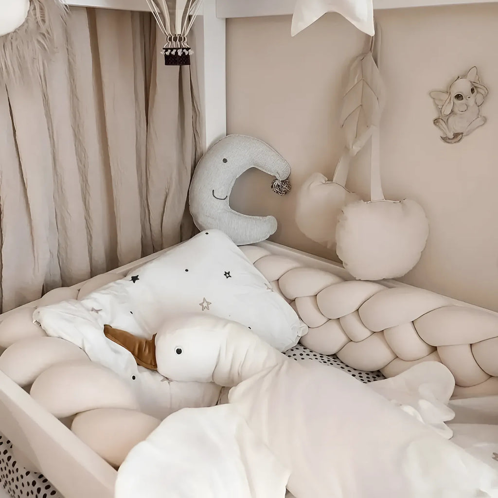 cream 4 strand braided crib bumper in white house bed with canopy and stuffed toys, scandi nursery
