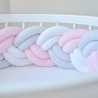 double braided cot bumper in pink and white color on the crib