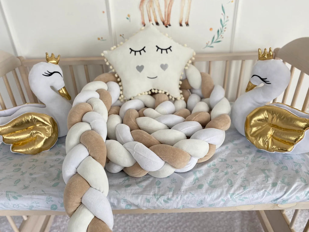 White milk cream beige 3-strand braided crib bumper in wooden crib with swan toys and star pillow, CottonNest