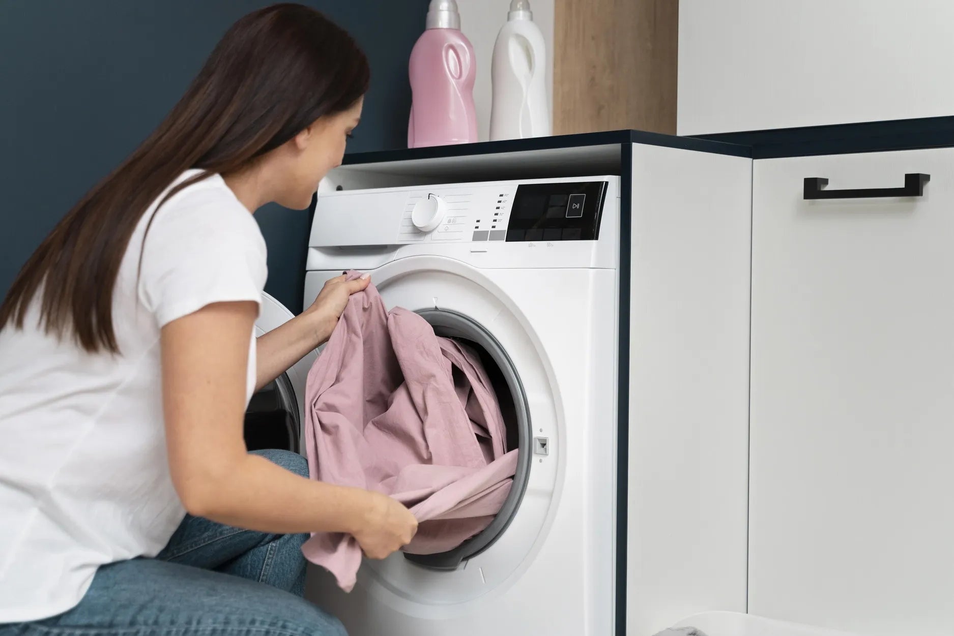 woman taking laundry from washing machine machine washable crib bumper care
